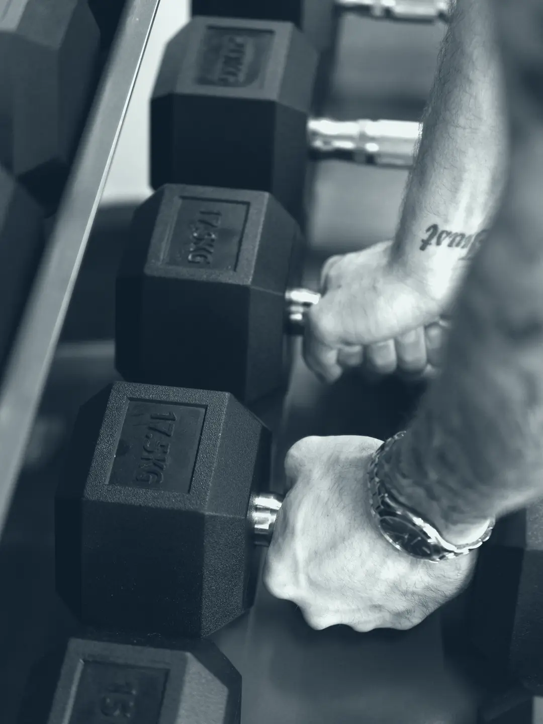 Hands lifting dumbbells from a rack